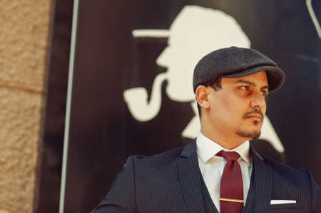 Portrait of retro 1920s english arabian business man wearing dark suit, tie and flat cap.の写真素材