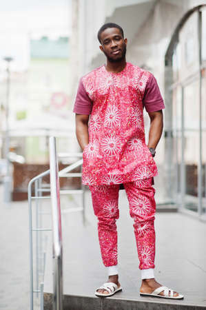 Portrait of a black young man wearing african traditional red colorful clothes.の写真素材