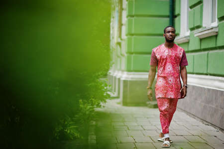 Portrait of a black young man wearing african traditional red colorful clothes.の写真素材