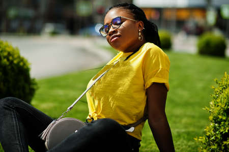 Portrait of black African American woman in yellow t-shirt and glasses.の写真素材