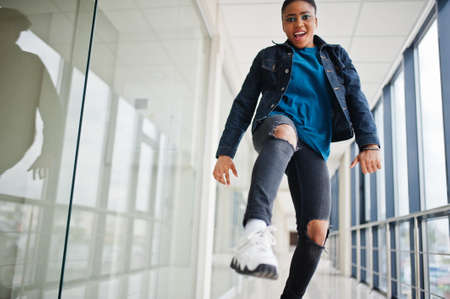 African woman in jeans jacket posed indoor.の写真素材