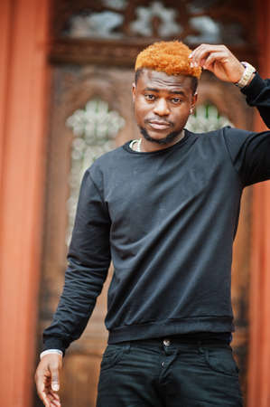 African red haired man wear black outfit posing outdoor.の写真素材