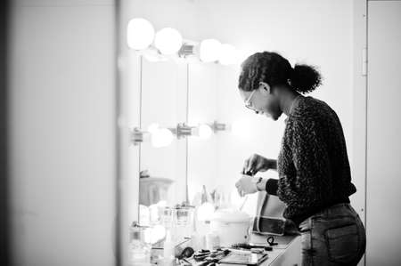 African American woman make-up artist at beauty saloon.