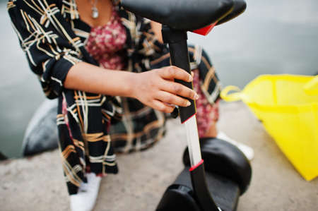 Beautiful african american woman sit near hoverboard. Black girl with yellow cloth eco bags...