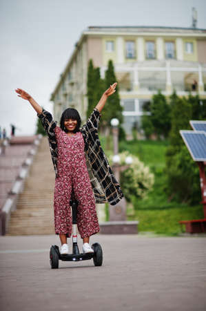 Beautiful african american woman using hoverboard. Black girl on dual wheel self balancing...