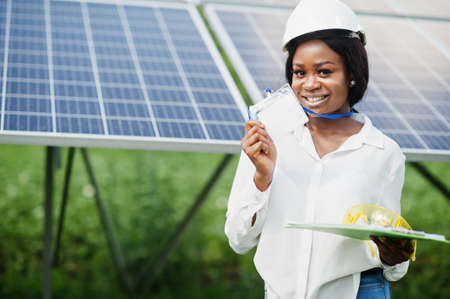 African american technician check the maintenance of the solar panels. Black woman engineer at solar station.の写真素材