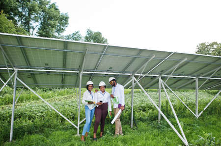 African american technician checks the maintenance of the solar panels. Group of three black...