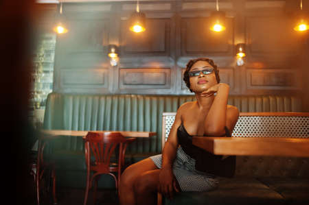 Portrait of african american woman, retro hairstyle posing at restaurant.