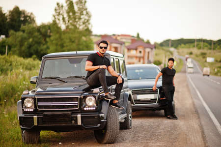 Two asian brothers man wear on all black posed near suv cars.の写真素材
