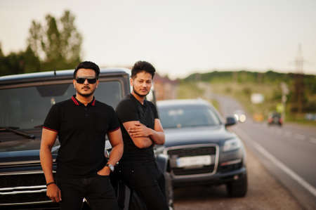 Two asian brothers man wear on all black posed near suv cars.の写真素材