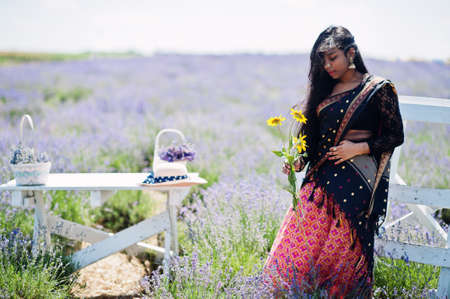 Beautiful indian girl wear saree india traditional dress in purple lavender field.