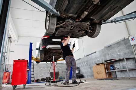 Car repair and maintenance theme. Mechanic in uniform working in auto service.