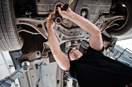 Car repair and maintenance theme. Mechanic in uniform working in auto service.