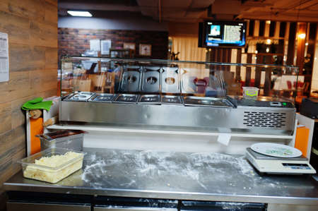 Female chef preparing pizza in restaurant kitchen.の写真素材