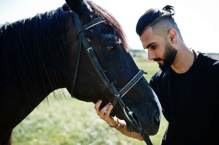 Arab tall beard man wear in black with arabian horse.の写真素材