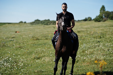 Arab tall beard man wear in black ride arabian horse.の写真素材