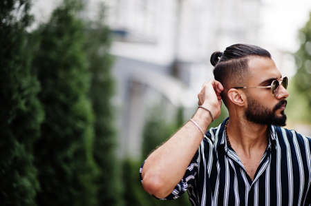 Successful arab man wear in striped shirt and sunglasses pose outdoor.の写真素材