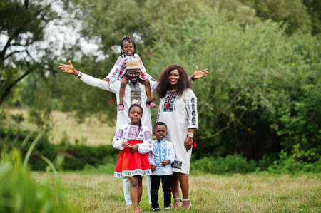 African family in traditional clothes at park.