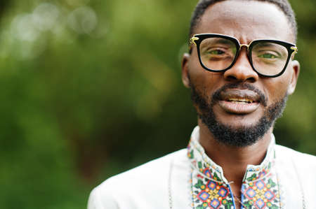 Portrait of african man in traditional clothes at park.