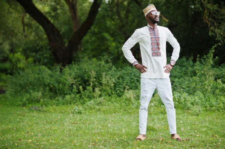 Portrait of african man in traditional clothes at park.の写真素材