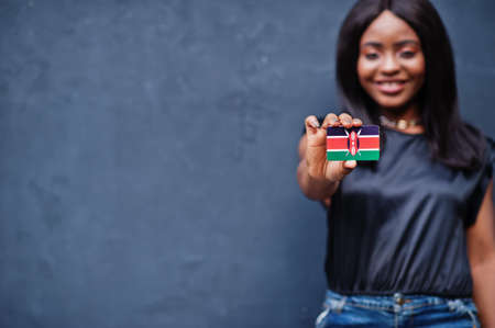 African woman hold small Kenya flag in hands.の写真素材