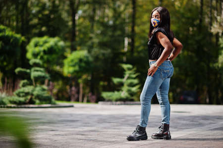 Fashionable african american woman, wear hand made face mask posing outdoor. New normal life.の写真素材