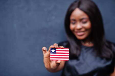 Proud to be liberian. African woman hold small Liberia flag in hands.の写真素材
