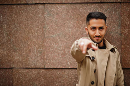 Stylish kuwaiti man at trench coat show finger to camera.の写真素材