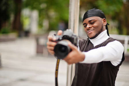 Young professional african american videographer holding professional camera with pro equipment....