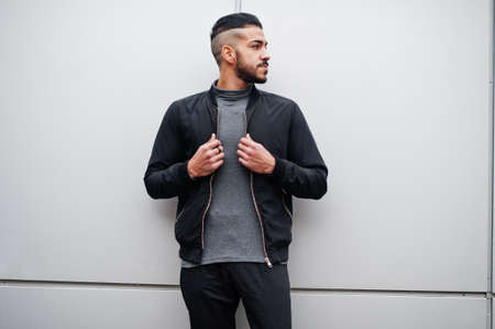 Portrait of stylish arab beard man wear gray turtleneck and black jaket. Arabian model guy against steel wall.の写真素材
