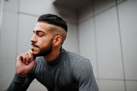 Portrait of stylish arab beard man wear gray turtleneck. Arabian model guy against steel wall.