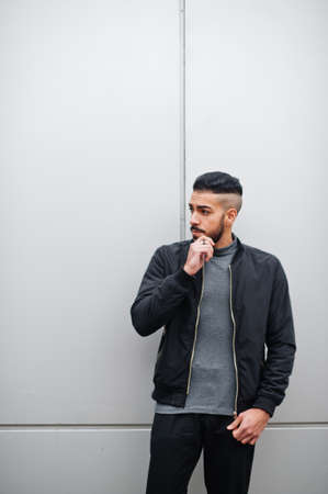 Portrait of stylish arab beard man wear gray turtleneck and black jaket. Arabian model guy against steel wall.の写真素材
