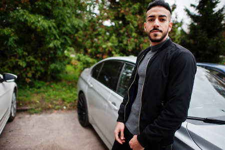 Portrait of stylish arab beard man wear gray turtleneck and black jaket. Arabian model guy stand...