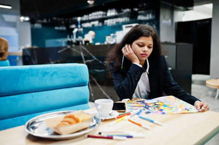 Indian artist woman wear formal paint picture, while sitting at cafe.の写真素材