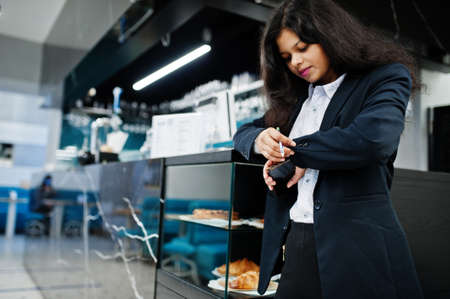Gorgeous indian woman wear formal posing at cafe near bar counter.