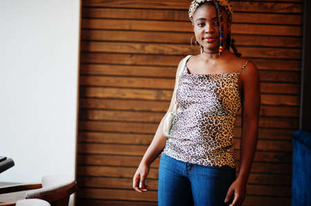 Lovely african american woman with dreadlocks in leopard outfit at cafe. Beautiful cool fashionable...
