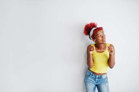 African american woman in yellow singlet and eyglasses against white wall.の写真素材