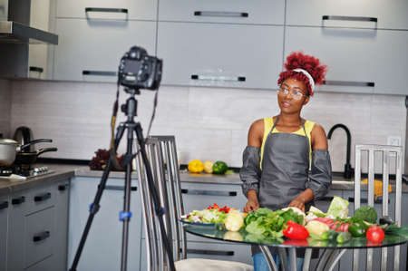 African american woman filming her blog broadcast about healthy food at home kitchen.の写真素材