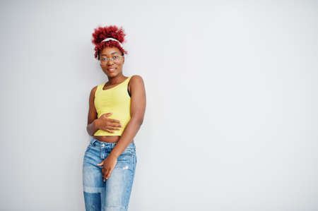 African american woman in yellow singlet and eyglasses against white wall.