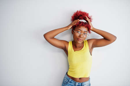 African american woman in yellow singlet and eyglasses against white wall.の写真素材