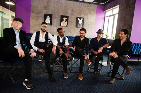 Group of handsome retro well-dressed man gangsters spend time at club. Multiethnic male bachelor mafia party in restaurant.の写真素材