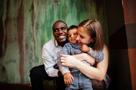 Happy multiethnic family with boy kid spend time at restaurant. Relationships of african man and white european woman.の写真素材