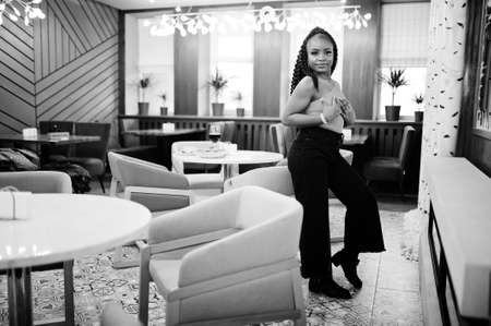 Portrait of attractive young african american woman wearing in green sweater and black jeans pose at...