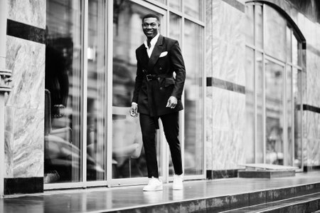 Portrait of young and handsome african american businessman in suit and white sneakers.の写真素材