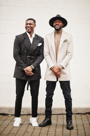 Two fashion black men. Fashionable portrait of african american male models. Wear suit, coat and hat.の写真素材