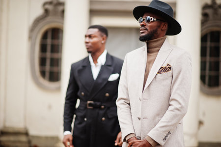 Two fashion black men. Fashionable portrait of african american male models. Wear suit, coat and hat.の写真素材