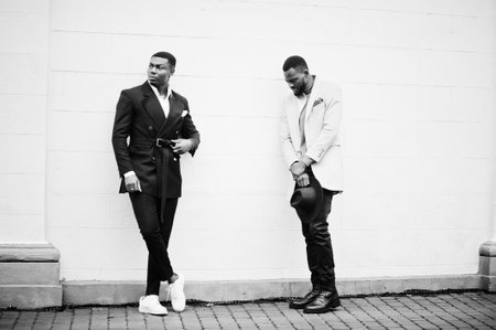 Two fashion black men. Fashionable portrait of african american male models. Wear suit, coat and hat.の写真素材