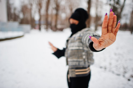 African muslim woman wear in black hijab scarf pose in winter day at Europe and show stop sign by hand.の写真素材