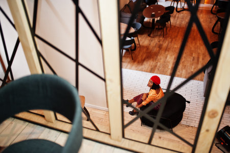 Elegant afro american woman in red french beret, big gold neck chain polka dot blouse and leather...