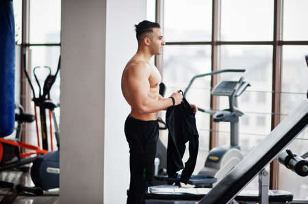 Muscular arab man training in modern gym. Fitness arabian men with naked torso doing exercises.の写真素材